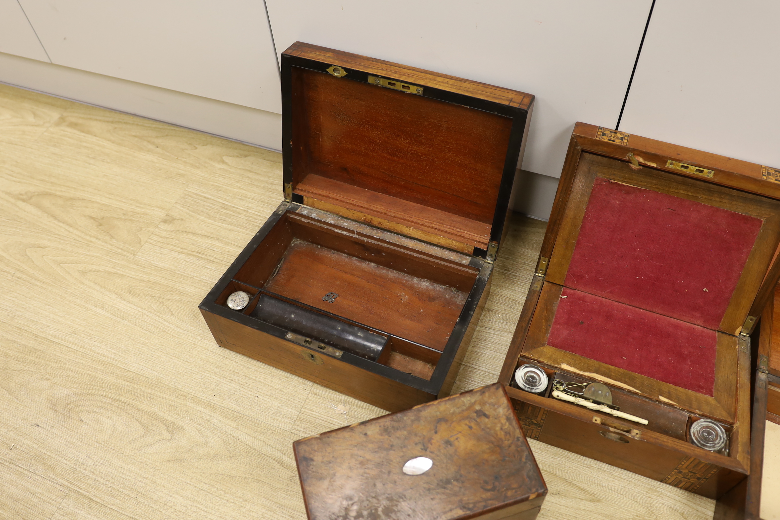 Three Victorian writing boxes and a tea caddy, largest 35cm wide, 15cm high, 24cm deep